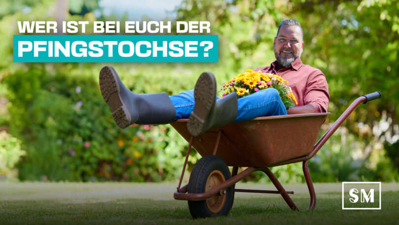 Chef ario Kattner sitzt lässig in eier Schubkarre, auf dem Schoß Blumen als typischer Pfingstschmuck.