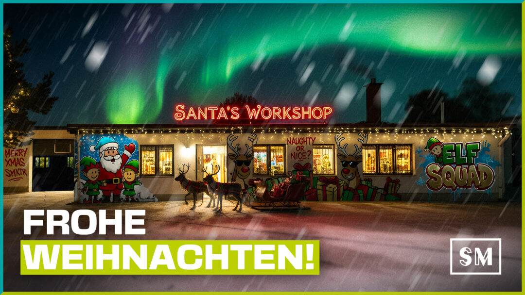 Festlich beleuchteter "Santa's Workshop" bei Nacht unter grünen Polarlichtern und fallendem Schnee. Das flache Gebäude ist mit bunten Graffiti-Motiven von Weihnachtsmann, Elfen ("Elf Squad") und Rentieren verziert. Vor dem Haus steht ein Rentierschlitten mit Geschenken. Im Vordergrund prangt der große Schriftzug "FROHE WEIHNACHTEN!" sowie das Logo "SM".