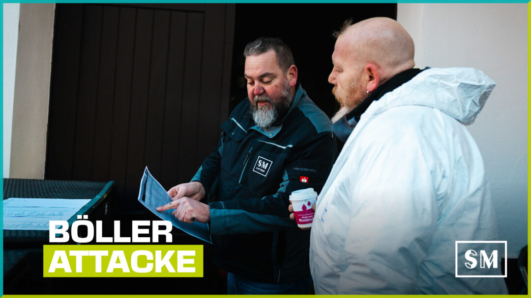Zwei Männer in Arbeitskleidung betrachten konzentriert ein Dokument; im Vordergrund der Schriftzug „Böller Attacke“.