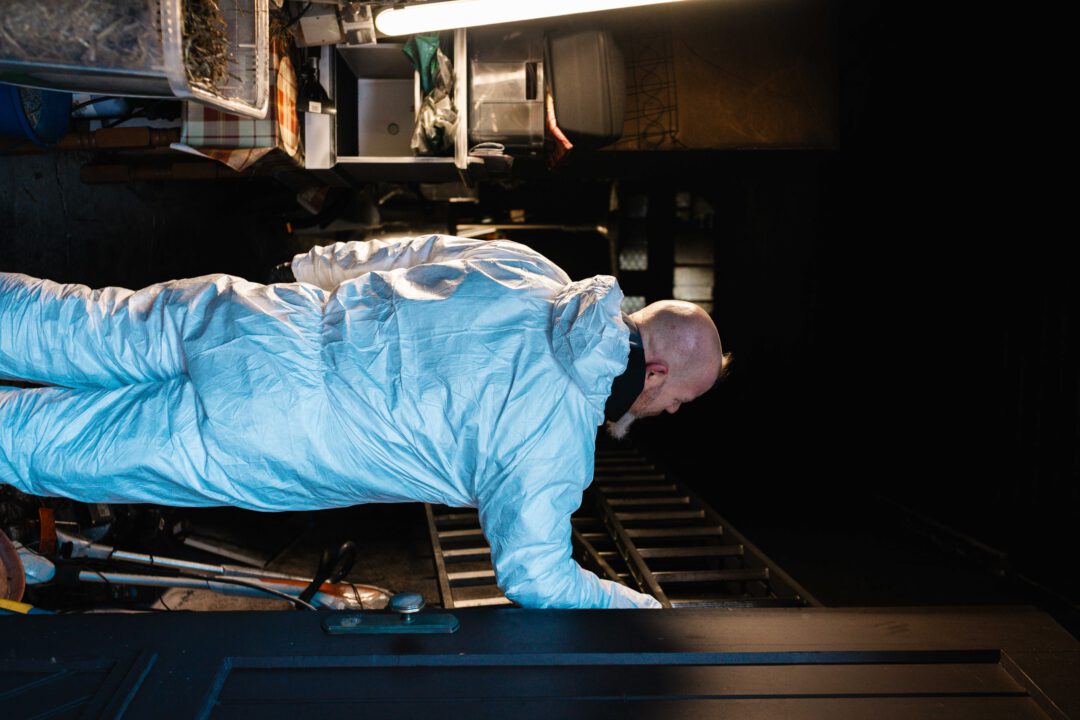 SM Kattner Mitarbeiter im Schutzanzug bei der Erstbegehung eines durch einen Böller-Anschlag verrußten Lagerraums