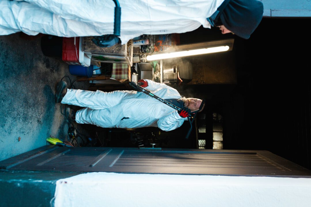 Professionelle Rußbekämpfung: Mitarbeiter räumt kontaminierte Gegenstände aus dem dunklen Kellerbereich.