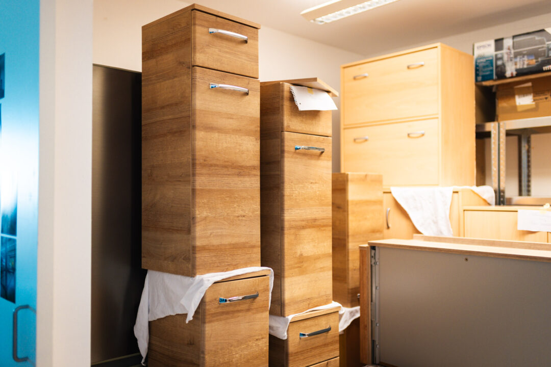 Fachgerecht verpackte und zwischengelagerte Holzmöbel in einem Trocknungslager nach einer Brandschadensanierung.