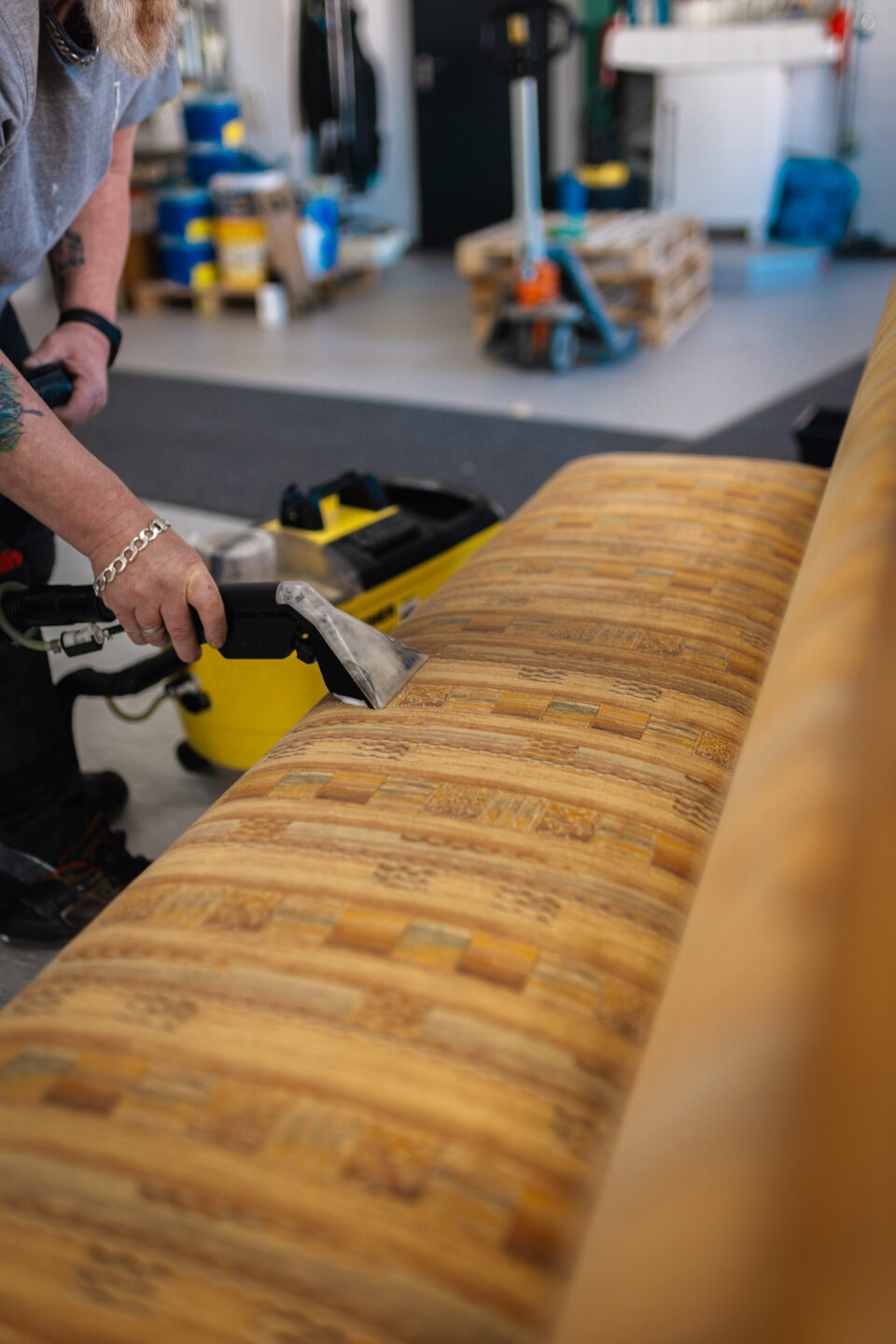 Tiefenreinigung von brandverschmutzten Polstermöbeln mit einem Sprühextraktionsgerät zur Entfernung von Brandgeruch und Rußpartikeln.