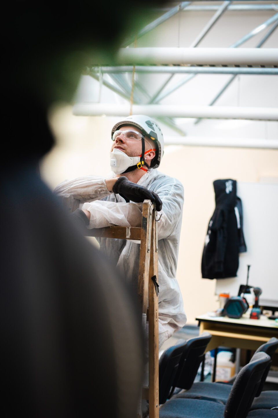 Mitarbeiter der Höhenservice Straß GmbH in Schutzkleidung und mit Helm bei der Vorbereitung zur Brandschadensanierung und Rußbeseitigung an einer Dachkonstruktion.